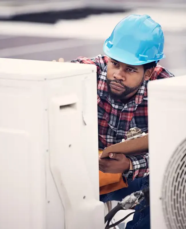 a man wearing a hard hat and holding a clipboard
