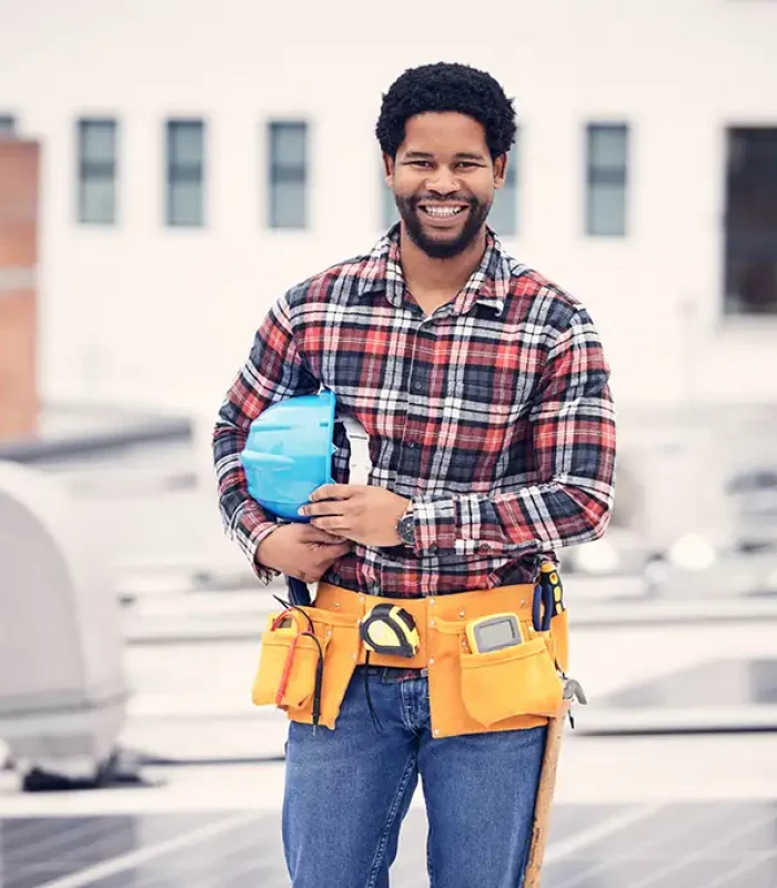 a man wearing a tool belt and holding a helmet