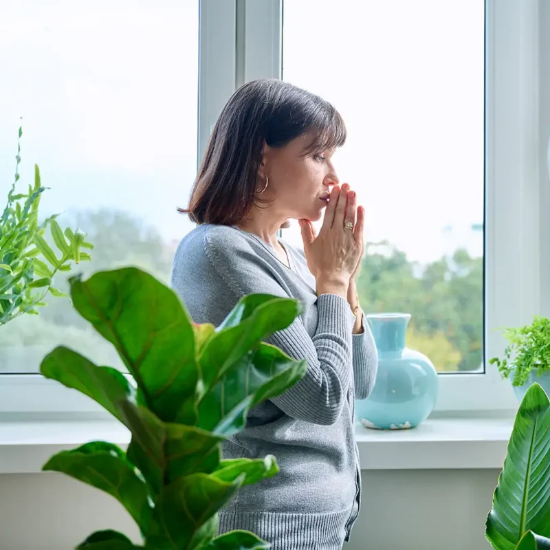 a woman standing in front of a window